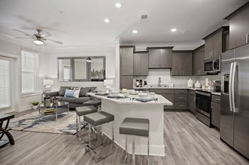 A white and black kitchen and living room with a table and chairs